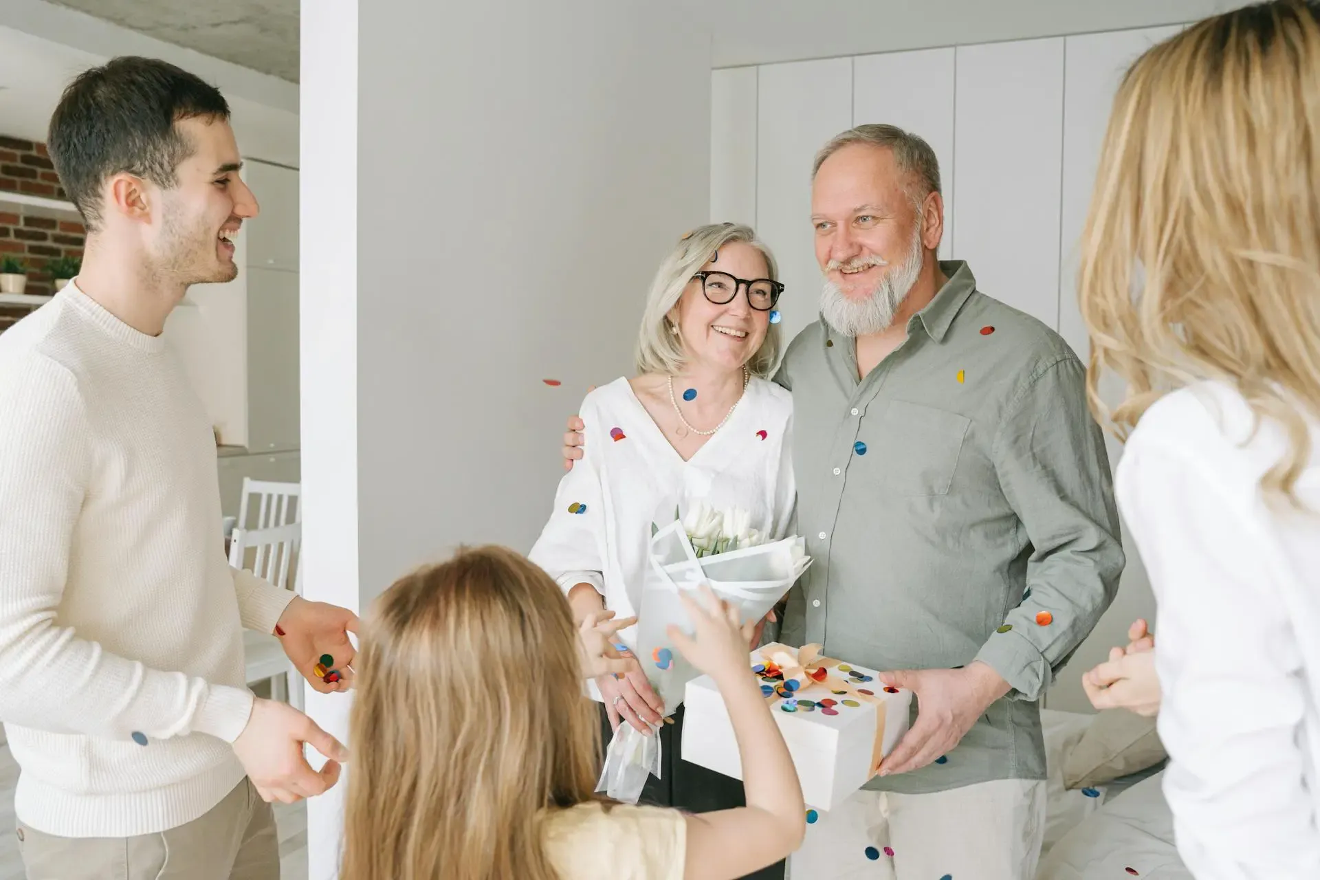 A joyful family celebrates a birthday at home, surrounded by colorful confetti and smiling faces.